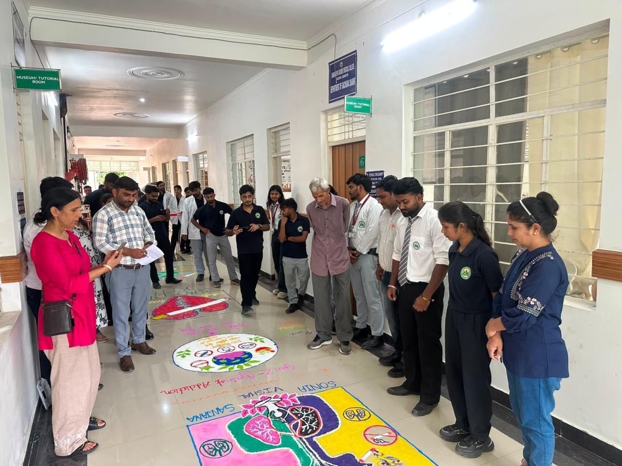 Students viewing rangoli creations in the college corridor
