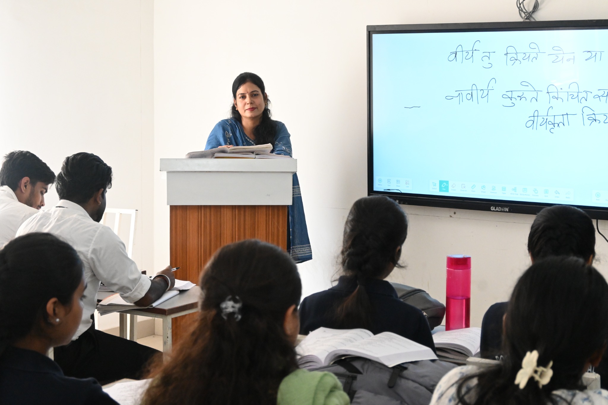 Faculty teaching BAMS students using a smart digital board